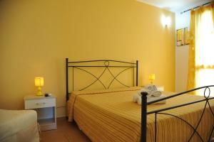 a bedroom with a bed with a yellow wall at B&B Erminia in Presicce