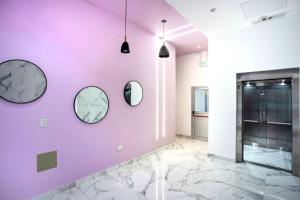 a hallway with three mirrors on a purple wall at ALQUILERES TEMPORARIOS MADRYN in Puerto Madryn