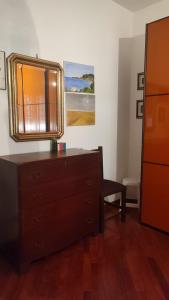 a bedroom with a dresser and a mirror on the wall at Montagnola House in Rome