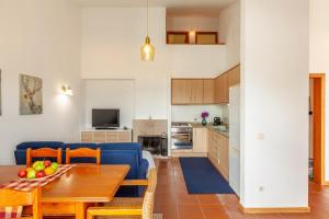 uma sala de estar com uma mesa e um sofá azul em Casa Nogueira - Minho's Guest em Pousadouros