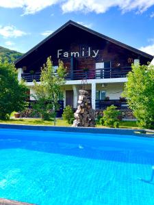uma casa com piscina em frente a um edifício em Chalet "Family" em Suskovo