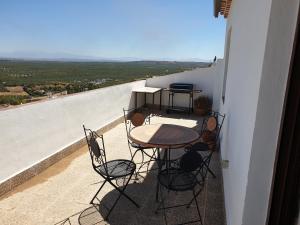 patio con mesa y sillas en el balcón en Alojamiento Rural Mirador del Valle, en Baños de la Encina