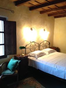 1 dormitorio con cama, lámpara y silla en Country House, en Zerbolò
