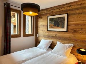 - une chambre avec un lit blanc et un mur en bois dans l'établissement Appartement 4 Chambres au Coeur des Gets - Haut Standing, Parking, Wifi, Balcon, Proche Commerces - FR-1-623-319, aux Gets