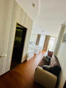 a living room with a couch and a tv at Hotel Albatros in Ureki