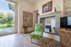 a living room with a fireplace and a green chair at La Rovettina Pet friendly house in Salò