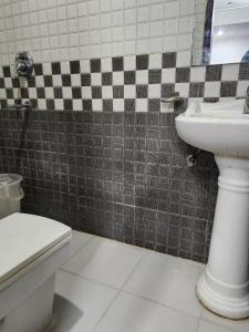 a bathroom with a sink and a toilet at Hotel Aerotech Suite in New Delhi