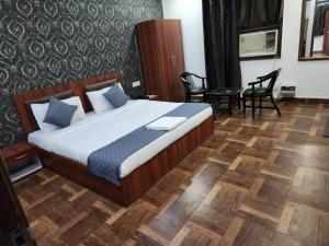 Hotel Aerotech Suite في نيودلهي: غرفة نوم بسرير وكراسي في غرفة