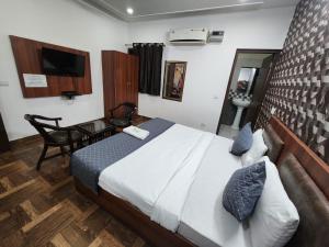 Dormitorio con cama, escritorio y TV en Hotel Aerotech Suite en Nueva Delhi
