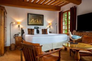 a bedroom with a bed and a table and a tv at Les Maisons de Lea, a member of Radisson Individuals in Honfleur