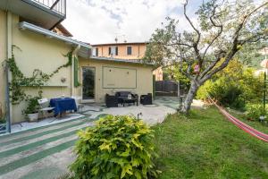 a patio with a table and a tree in a yard at La Rovettina Pet friendly house in Salò