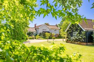 une maison avec une cour arborée dans l'établissement Foxhole Cottage, à Stowmarket