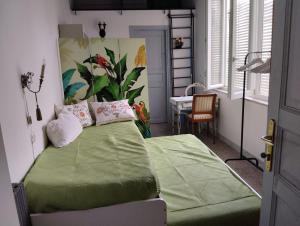 Schlafzimmer mit einem Bett mit grüner Bettwäsche und einem Tisch in der Unterkunft Lacasadilu in Neapel