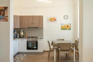 a kitchen with a table and chairs and a kitchen with a clock at Le Case di Franca in Trapani