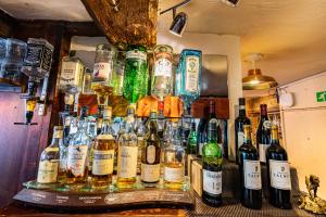 a bunch of bottles of alcohol on a bar at Crown Hotel Cotswold in Blockley