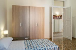 a bedroom with a bed and a large wooden cabinet at Le Case di Franca in Trapani