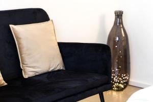 une chaise noire avec un oreiller et un vase en verre dans l'établissement Carly's Rooms, à Nago-Torbole