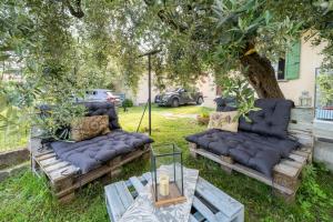 un gruppo di divani posti sotto un albero di La Rovettina Pet friendly house a Salò