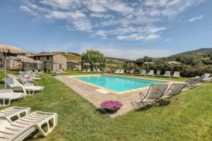 a swimming pool with lounge chairs and a yard at Agriturismo Podere San Giorgio in Radicofani
