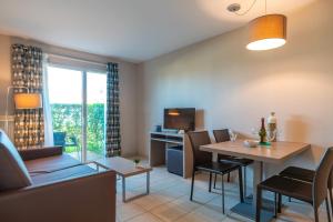 a living room with a table and a dining room at Les Thermes 508 - Appt avec piscine partagée in Concarneau