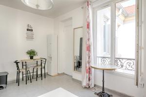 a living room with a table and a window at On Stage - Appartement pour 3 personnes in Ivry-sur-Seine