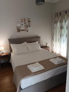 um quarto com uma cama grande com duas toalhas em Vivian's cozy apartment em Lárissa