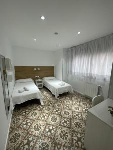 バルセロナにあるオスタル ノヴァバルセロナのベッド2台とフロアが備わるホテルルームです。