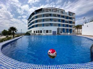 a pool with a ball in the water in front of a building at Appart-Hotel cabo dream in Cabo Negro
