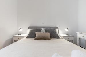 a bedroom with a white bed with two lamps at Naxian White House In Glinado in Glinado Naxos