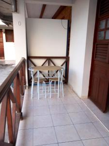 una mesa y sillas sentadas en un suelo de baldosa en Appartement cosy au Vauclin - 35 m² avec balcon jardinise, en Le Vauclin