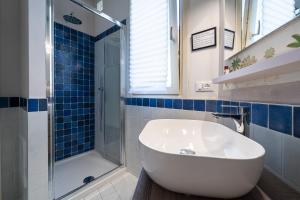 a bathroom with a white tub and a shower at La Rovettina Pet friendly house in Salò +25 photos
