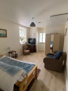 sala de estar con cama y sofá en Geraldine House, en Isla de Valentia