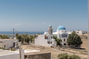 Biały kościół z niebieską kopułą na wzgórzu w obiekcie Naxian White House In Glinado w mieście Glinado Naxos