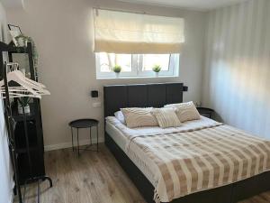a bedroom with a bed with a striped blanket and a window at Apartament Niko Nad Zatoką Pucką in Puck