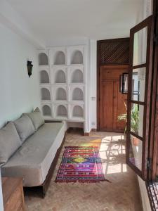 uma sala de estar com um sofá e uma porta em Dar S'BAH em Fez