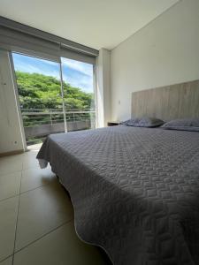 une chambre avec un grand lit et une grande fenêtre dans l'établissement Moderno Penthouse cartago centro vista al rio, à Cartago