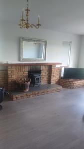 a living room with a brick fireplace and a mirror at Valley lodge in Belfast