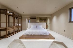 a bedroom with a large white bed and shelves at Sevasti Seaview Suite in Koskinou
