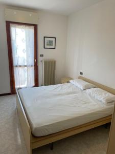 a bedroom with a large bed with white sheets and a window at Duca degli Abruzzi in Caorle