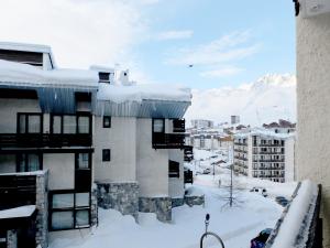 a building covered in snow with mountains in the background at Studio Tignes, 1 pièce, 5 personnes - FR-1-502-497 in Tignes