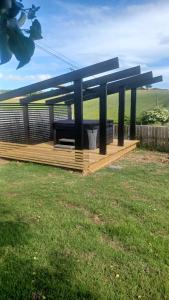 a pavilion with a bench in a grass field at Valley Lodge 3 BR Retreat in Craigantlet Hills in Belfast