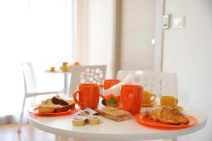 una mesa con dos platos de comida y tazas de café en B&B Erminia, en Presicce