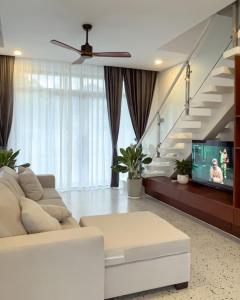 a living room with a white couch and a tv at The Rivera Kampot in Kampot