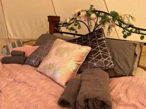 a bed with pillows and a flower arrangement on it at Belinda Bell Tent in Poulton le Fylde