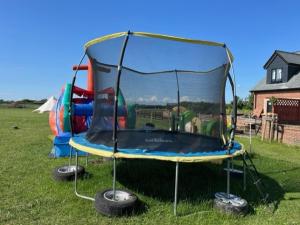 a trampoline in a field with tires around it at Belinda Bell Tent in Poulton le Fylde