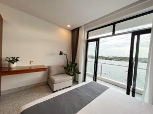 a bedroom with a bed and a large window at The Rivera Kampot in Kampot