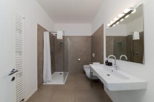 a bathroom with two sinks and a toilet and a mirror at Carly's Rooms in Nago-Torbole +46 photos
