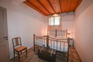 a bedroom with two bunk beds and a chair at Dream summer house in Tinos in Tinos Town