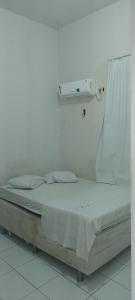 uma cama num quarto com uma parede branca em San Luis em São Luís