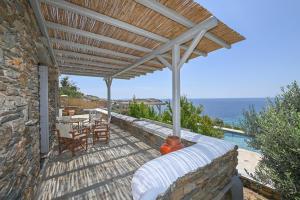 a patio with a wooden pergola and a table and chairs at Dream summer house in Tinos in Tinos Town